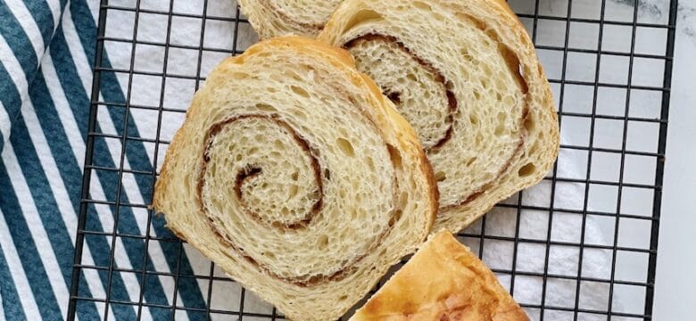 Cinnamon Swirl bread sliced on a cooling rack.
