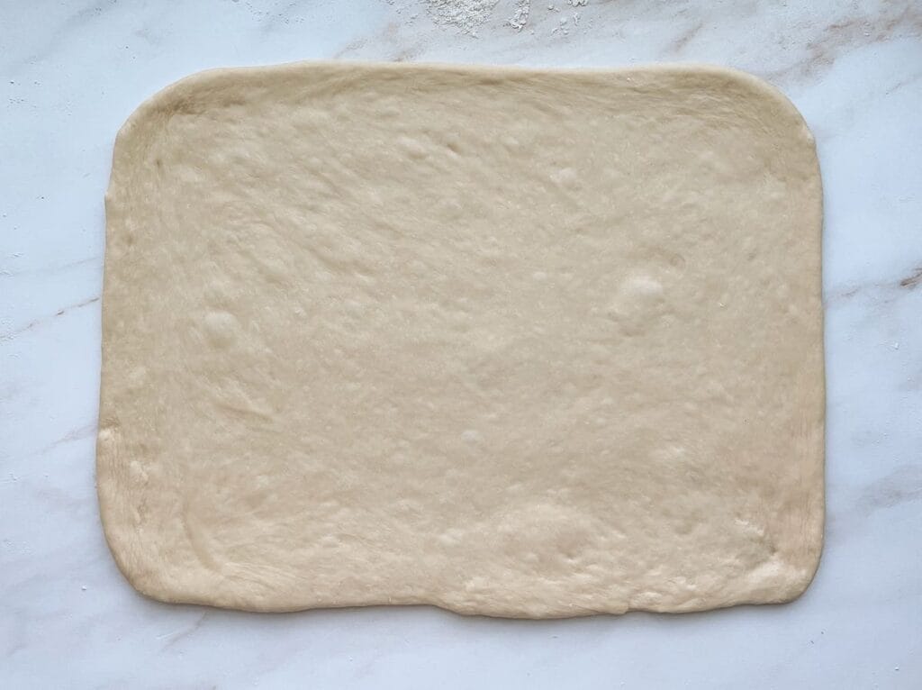 Parker House Roll dough rolled into a rectangle.