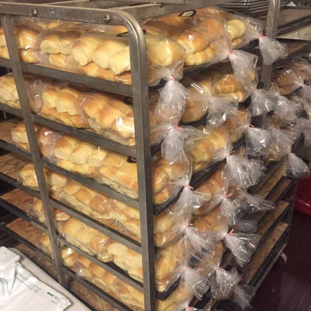 Bags of rolls on a proofing rack.