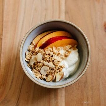 Granola, yogurt and fruit in a bowl.