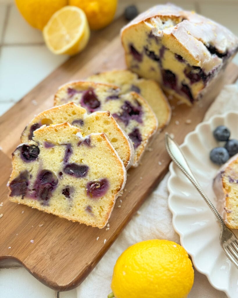 Lemon blueberry bread sliced on a bread board.